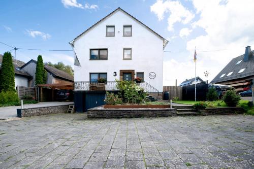 a white house with a courtyard in front of it at Ut Huuske in Dorsel