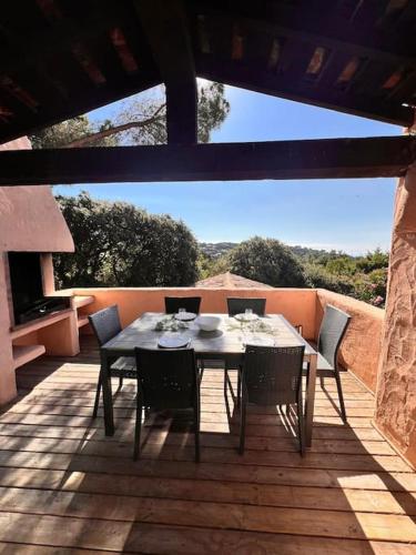 une table et des chaises sur une terrasse avec vue dans l'établissement Logement Mésange600m à pied de SantaGiulia Jacuzzi, à Porto-Vecchio