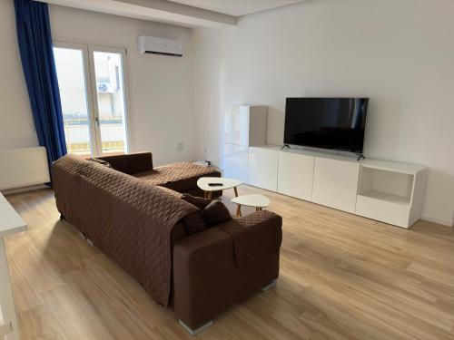 a living room with a couch and a flat screen tv at Fabio's Place in Castelvetrano Selinunte