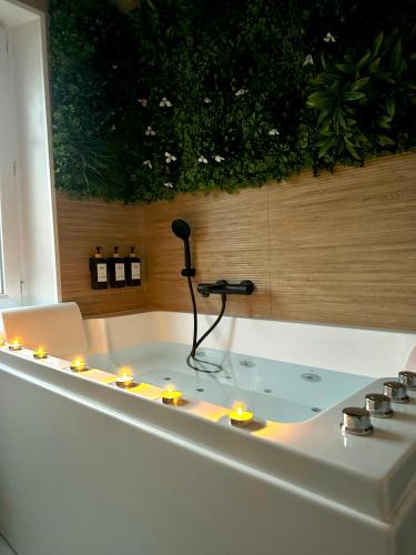 La salle de bains est pourvue d'une baignoire avec des bougies. dans l'établissement Maison cosy jungle urbaine, à Dammartin-en-Goële