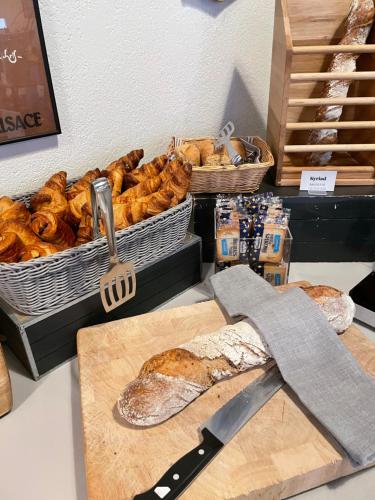 a counter with a basket of bread and pastries at Hôtel Restaurant Kyriad Mulhouse Nord Illzach in Illzach
