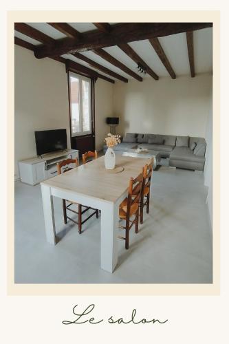 un salon avec une table et un canapé dans l'établissement LA FERME DU PERE CAMILLE, à Pars-lès-Romilly