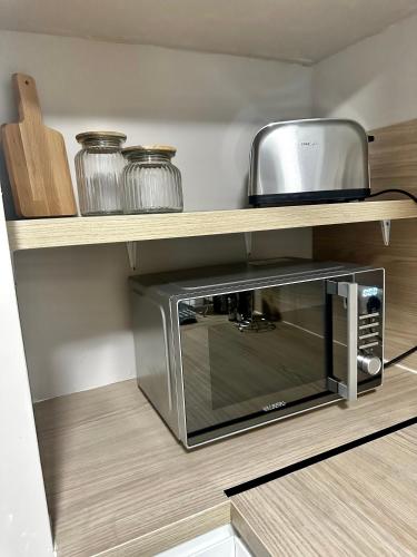 un four micro-ondes sur une étagère dans une cuisine dans l'établissement Maison cosy jungle urbaine, à Dammartin-en-Goële