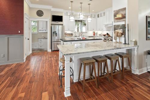 a kitchen with a large island with bar stools at Luxury 5 BR 4 Bath, Hot Tub, Outdoor Kitchen, Across Street from Kyle Field! in College Station