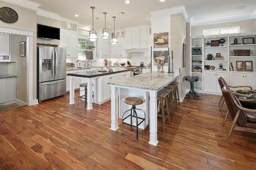 a kitchen with white cabinets and a island with a counter top at Luxury 5 BR 4 Bath, Hot Tub, Outdoor Kitchen, Across Street from Kyle Field! in College Station