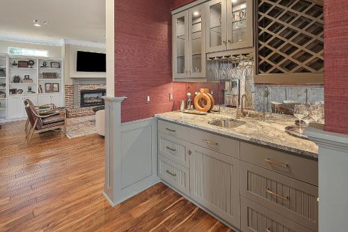 a kitchen with a sink and a wine cellar at Luxury 5 BR 4 Bath, Hot Tub, Outdoor Kitchen, Across Street from Kyle Field! in College Station