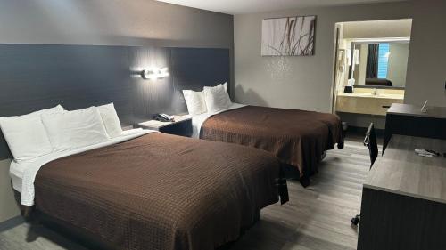 a hotel room with two beds and a mirror at Economy Inn in Hope