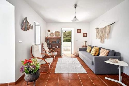 a living room with a blue couch and chairs at Casa Azul da Corisca in São Lourenço