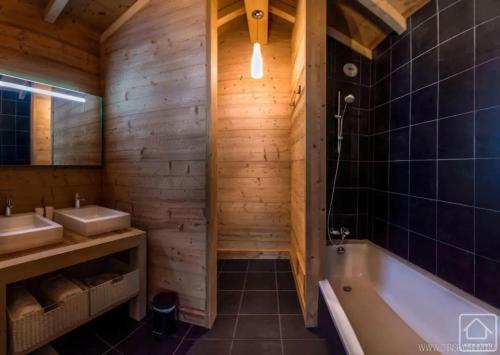 une salle de bain avec une baignoire et un lavabo dans l'établissement Chalet grandiose au pied des pistes de Morzine - Vue imprenable, à Morzine