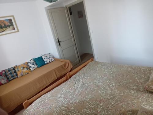 a small room with two beds and a door at Maison indépendante à la ferme in Palleville