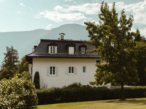 a large white house with a black roof at Hotel Villa Freiheim in Merano