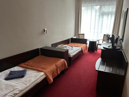 two beds in a room with red carpet at Hotel *** NAT Ustroń in Ustroń