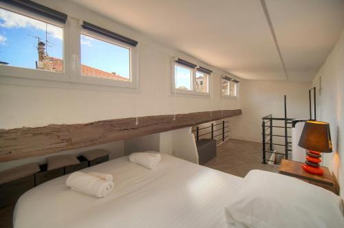 - une chambre avec un lit blanc et 2 fenêtres dans l'établissement Immogroom - T3 - Suquet - AC, à Cannes