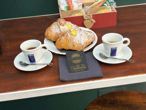 two cups of coffee and croissants on a counter at Loto Luxury in Trani