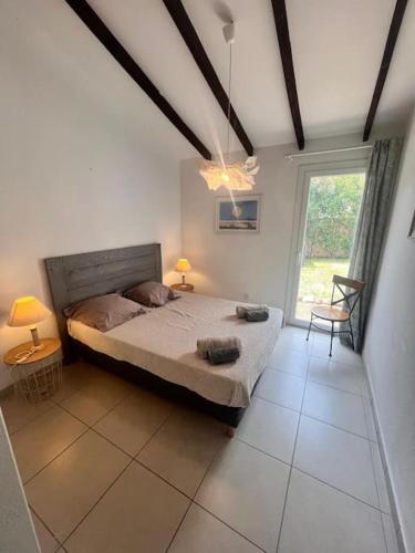 une chambre avec un grand lit et une fenêtre dans l'établissement Logement Linotte, 600m à pied Santa Giulia Jacuzzi, à Bocca del Oro