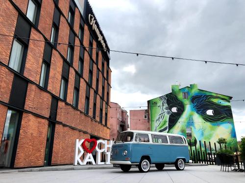 a blue and white van parked in front of a building at Hampton By Hilton Kalisz in Kalisz