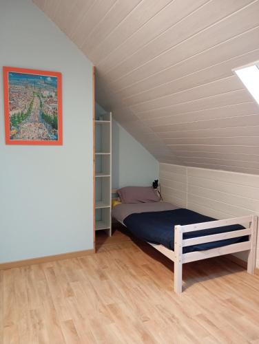 une chambre avec un lit dans un grenier dans l'établissement Maison de ville avec jardin-Rêve à Rixheim!, à Rixheim