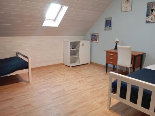 a bedroom with a bed and a desk and a refrigerator at Maison de ville avec jardin-Rêve à Rixheim! in Rixheim