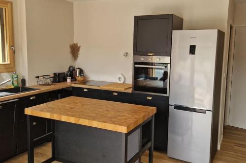 Il comprend une cuisine équipée d'un réfrigérateur blanc et d'une cuisinière. dans l'établissement Appartement montagne 50m2 2 chambres et un canapé lit, aux Gets