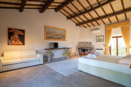 una camera da letto con un letto, un divano e un camino di Agriturismo Cerrosughero a Canino