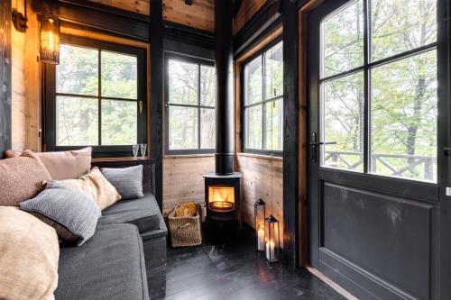 a living room with a couch and a wood stove at Les cabanes des Dolimarts in Bohan