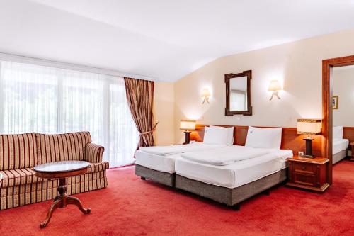 a hotel room with a bed and a couch at Hotel Belvedere in Ohrid