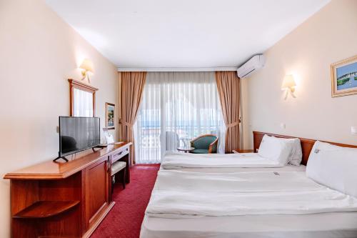 a hotel room with two beds and a television at Hotel Belvedere in Ohrid