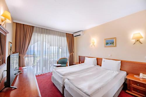 a hotel room with a bed and a television at Hotel Belvedere in Ohrid