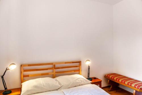 a bedroom with a white wall and a bed with two lamps at Ferienhaus Birnberg in Leogang