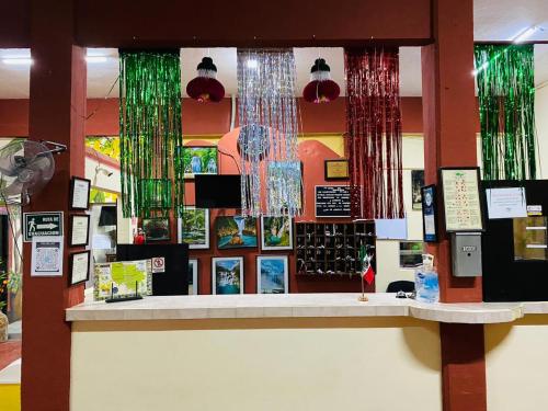 a counter in a store with green and red curtains at Hotel Del Valle in El Naranjo