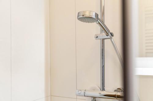 a shower head in a bathroom next to a mirror at Ferienhaus Birnberg in Leogang