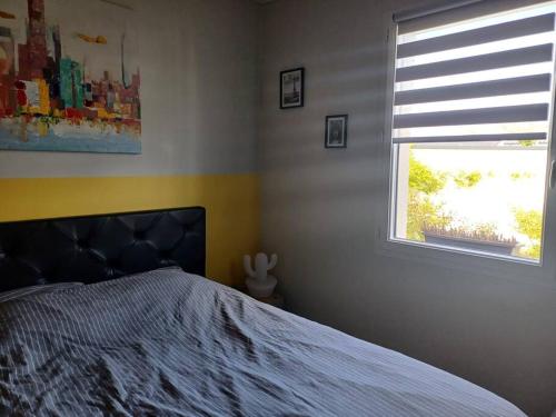 ein Schlafzimmer mit einem Bett und einem Fenster in der Unterkunft Maison individuelle in Neuville-du-Poitou