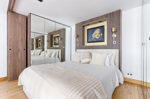 - une chambre avec un grand lit blanc et des miroirs dans l'établissement Duplex à deux pas des Champs Elysée, à Paris