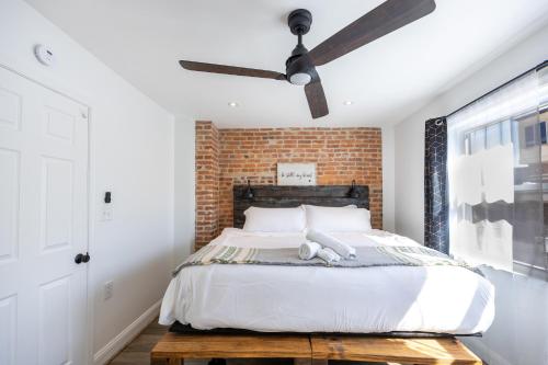 a bedroom with a brick wall and a bed with a ceiling fan at Charming 2BR Townhouse with Patio & Parking in DC in Washington