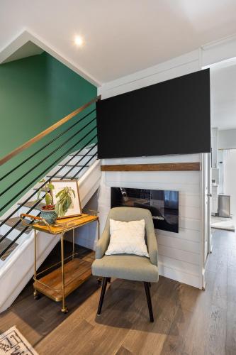 a living room with a chair and a staircase at Charming 2BR Townhouse with Patio & Parking in DC in Washington