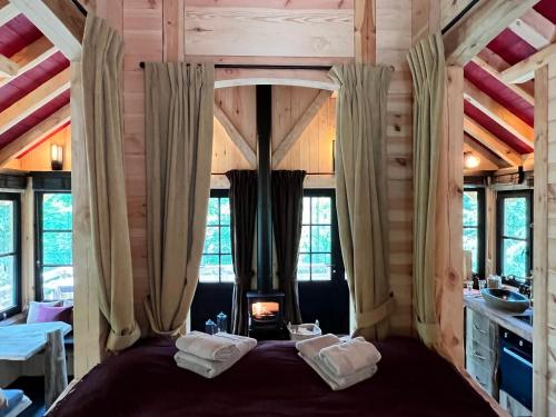 a bedroom with a large bed in a room with windows at Les cabanes des Dolimarts in Bohan