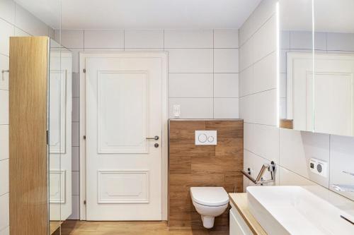 a bathroom with a toilet and a white door at Ferienwohnung Pfeffer in Leogang