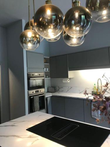 a kitchen with silver bowls hanging from the ceiling at Historic manoir in Vire Normandy elegance in a semi-rural setting ideal for groups and families in Vire