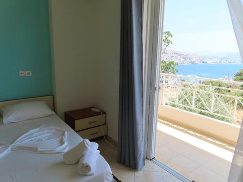 a bedroom with a bed and a view of the ocean at Mariana Apartments in Sarandë