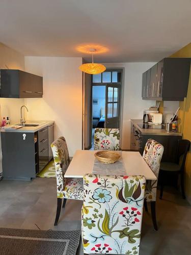 une cuisine avec une table et des chaises dans une cuisine dans l'établissement Appartement Remparts de Guérande, à Guérande