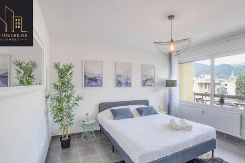 a bedroom with a bed and a large window at Appartement City Mountain in Cluses
