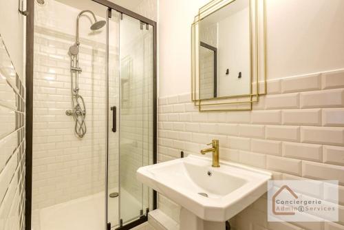 une salle de bain blanche avec un lavabo et une douche dans l'établissement Escapade paisible 2 à 4 voyageurs, à Monplaisir