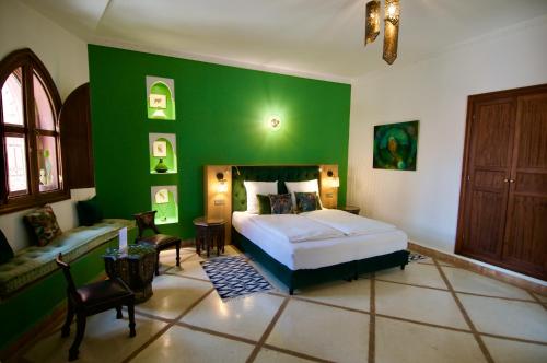 a bedroom with a bed and a green wall at La Claire Fontaine in Marrakech