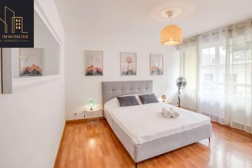 a white bedroom with a large bed in a room at Appartement Pastel in Cluses