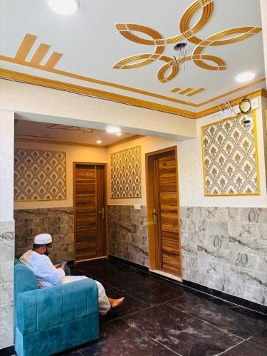 a man sitting on a couch in a living room at The Aziz Residency in New Delhi