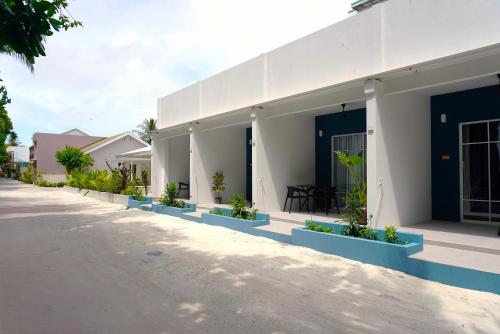 a building with potted plants on the side of it at TME Retreats Dhigurah in Dhigurah
