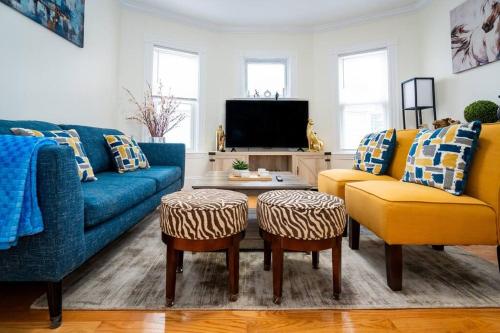 a living room with a blue couch and two yellow chairs at 14b-Newly Renovated, Uniquely decorated Apartment in Boston
