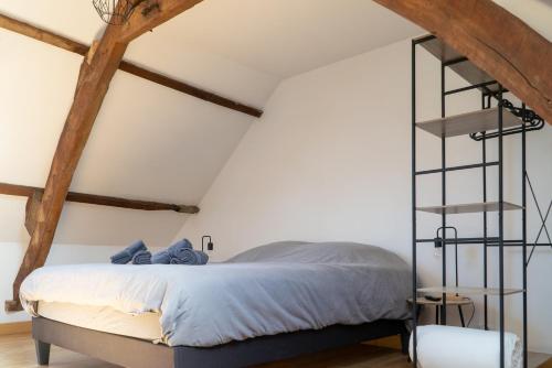 une chambre avec un lit dans un grenier dans l'établissement 'Maison Lison' le Calme en ville, à Annoeullin