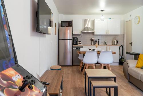 une cuisine et un salon avec une table et des chaises dans l'établissement 'Maison Lison' le Calme en ville, à Annoeullin