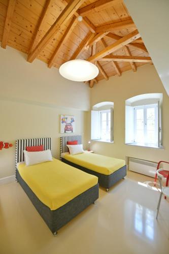 two beds in a room with wooden ceilings at Hydra Kamini Beach Thea in Hydra